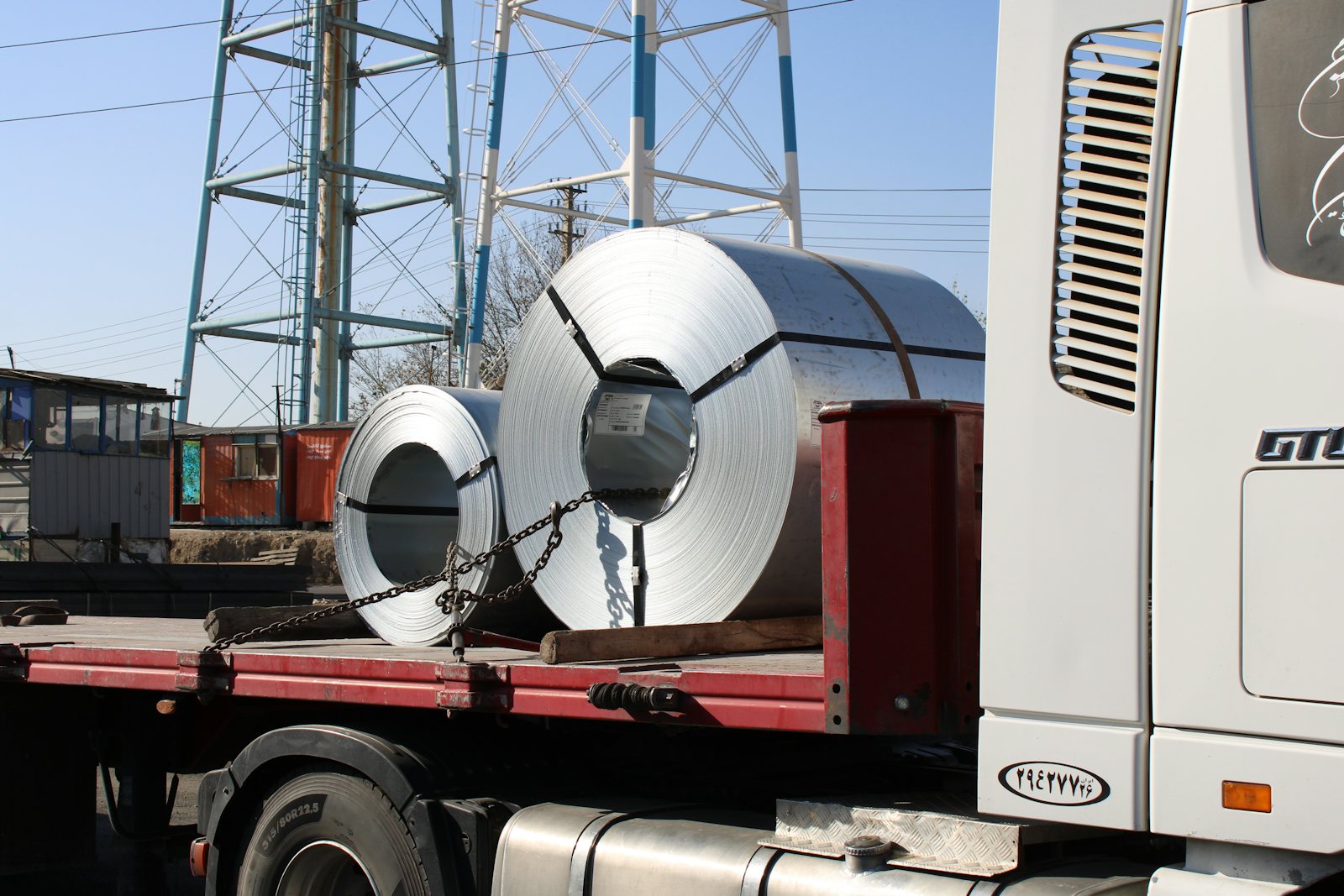 A steel coil strapped down on a flatbed for delivery